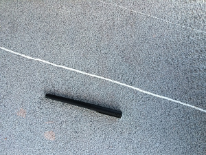 Traces of two parallel veins with different thicknesses of their in-fillings as seen on a cut and polished surface of a building stone in northern Spain. Pen for scale.